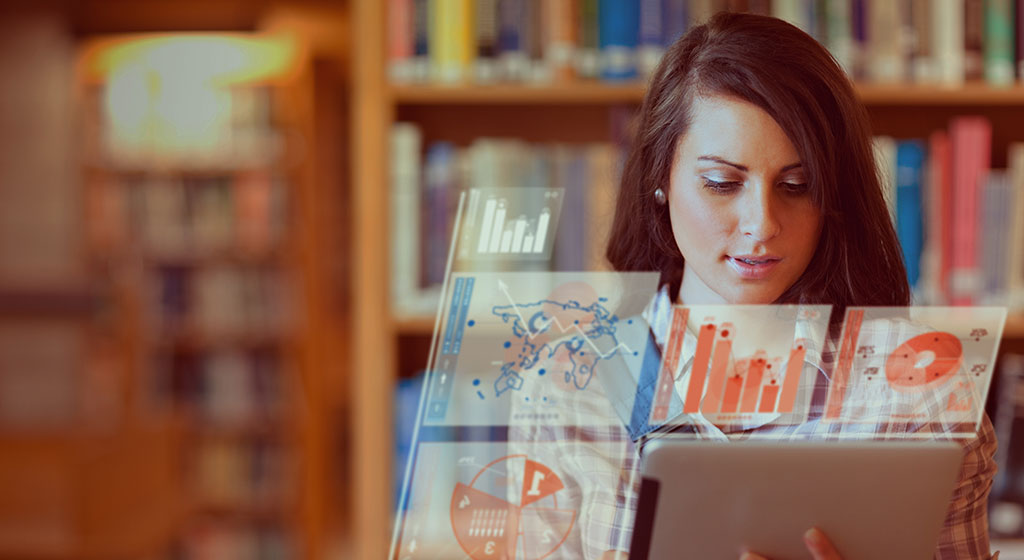 Woman looking at a tablet with futuristic display, showing graphs.