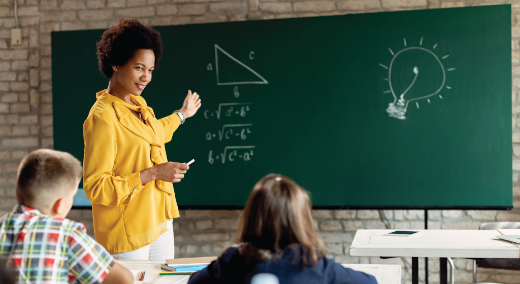 Woman teaching math to young students.