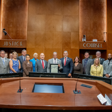 The University of Houston-Downtown President loren blanchard, houston mayor john whitemire, and council member mario castillo at houston city hall for UHD's Proclamation Day. UHD staff, student leaders and leadership team smile.