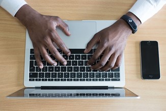 hands typing on a laptop